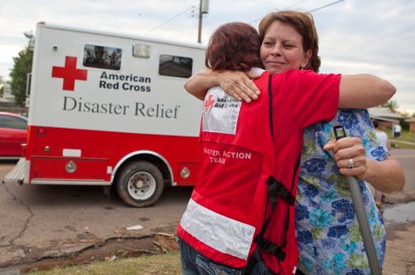 May 21, 2013. Moore, Oklahoma. Red Cross volunteer Angela Clemins hugs Moore resident Donna Giedrocz. Giedrocz has spent the day clearing debris from her home and expresses gratitude at the warm meal Clemins has brought her. Photo by Talia Frenkel/American Red Cross